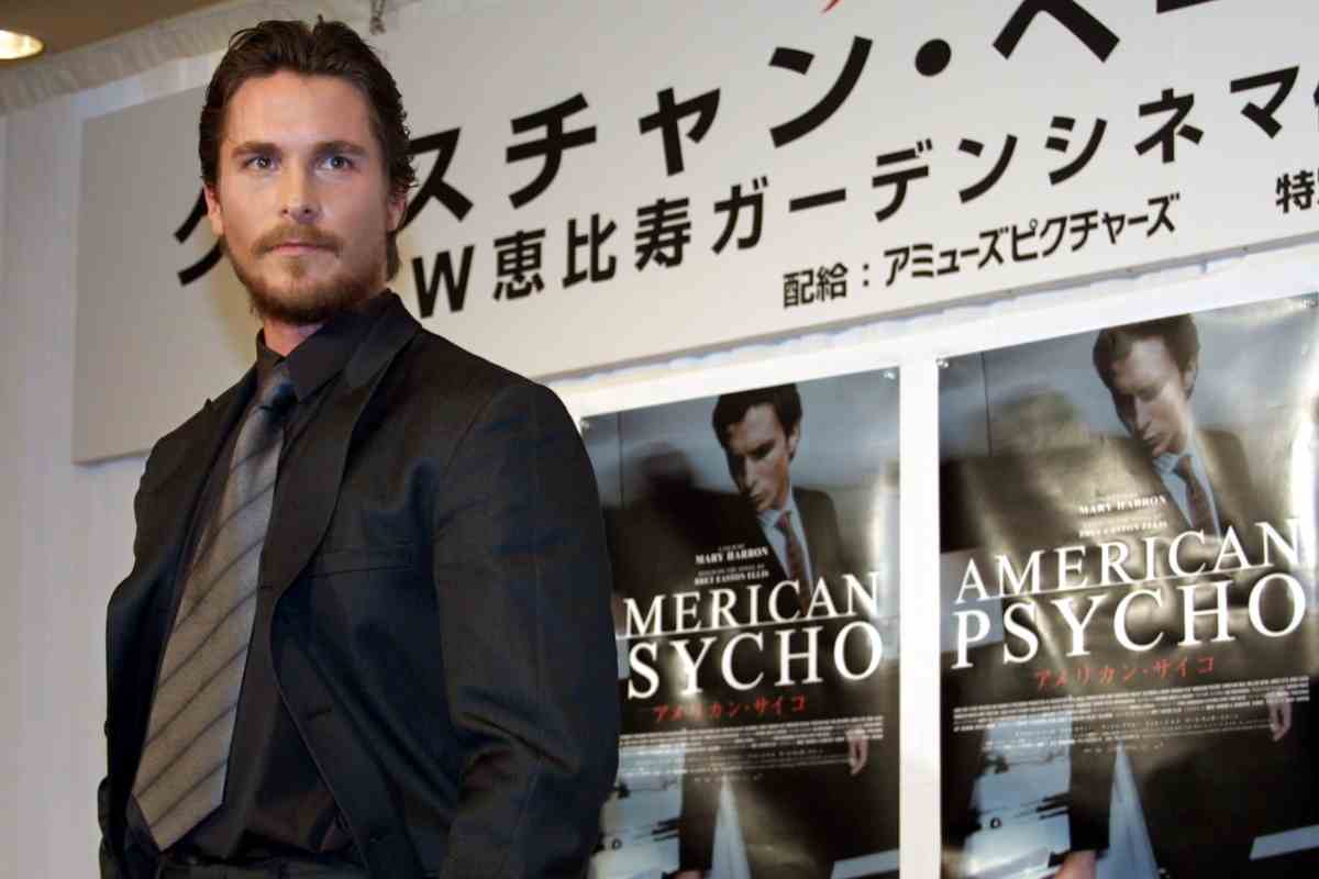 Christian Bale, alle sue spalle delle locandine giapponesi di American Psycho
