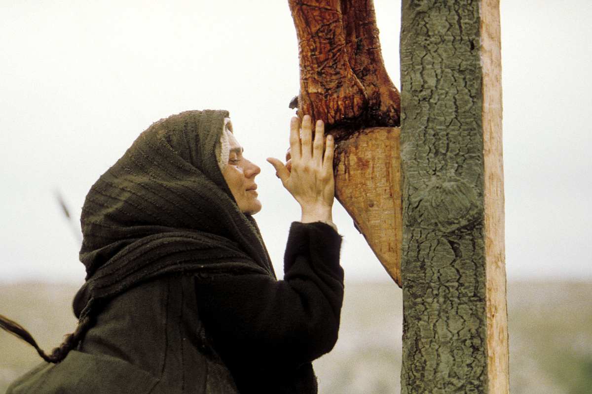 Una scena del film La Passione di Cristo: Maria la madre di Gesu' che bacia i piedi del Cristo crocefisso