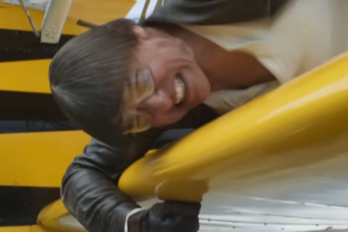 Tom Cruise in una scena del film appeso all'ala di un aereo