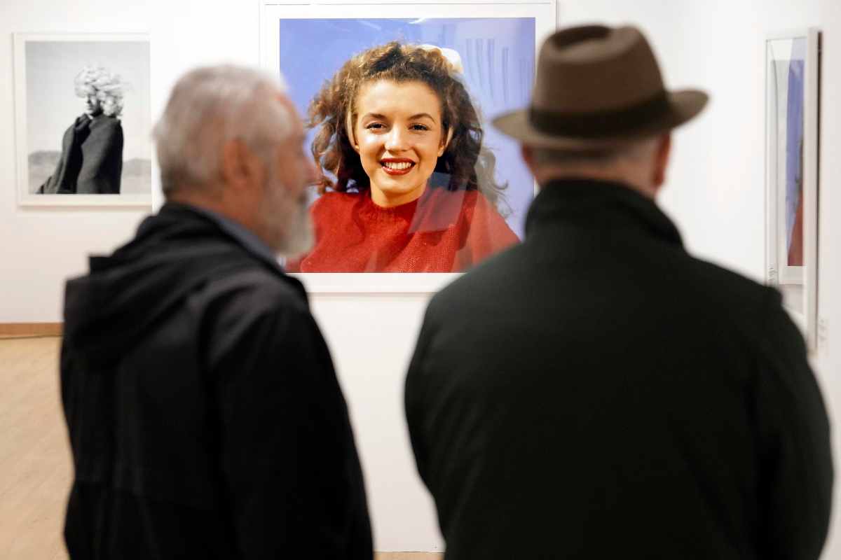 Mostra fotografica di Marilyn Monroe, due uomini che guardano una sua foto di lei ancora mora