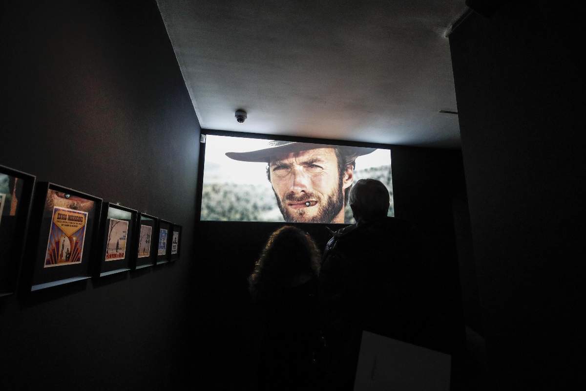 Una stanza buia, in fondo lo schermo di un cinema con il volto di Clint Eastwood con il cappello da cowboy