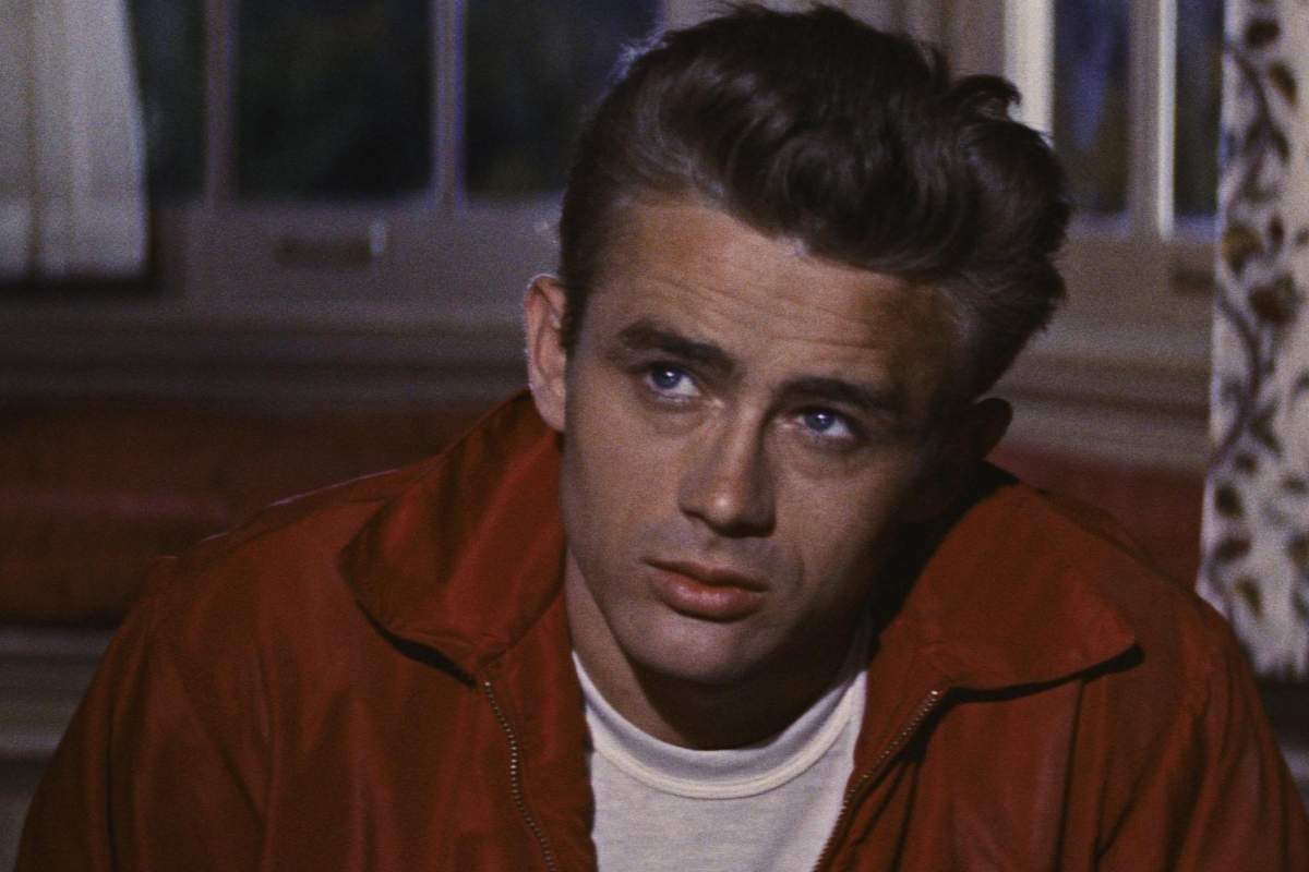 James Dean sul set con una maglietta bianca e una camicia rossa indosso