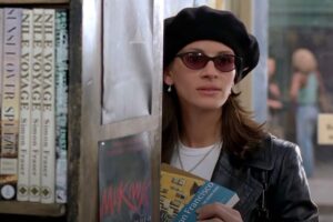 Julia Roberts in una scena del film dentro la libreria con alcuni libri in mano