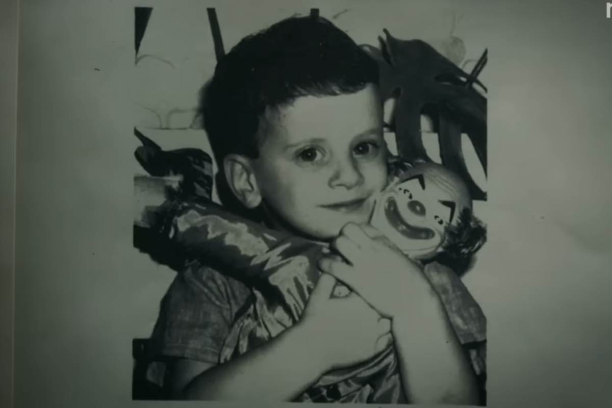 Un bambino in foto con in mano un pupazzo a pagliaccio