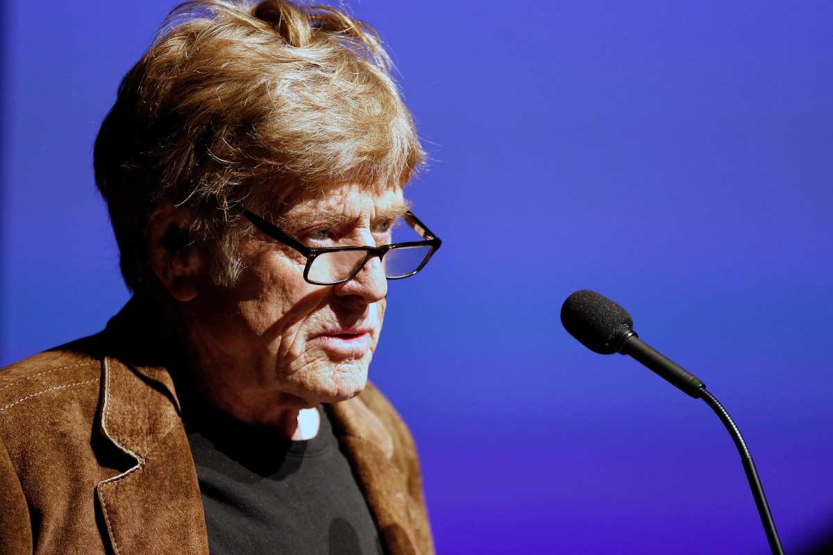 Robert Redford con un microfono davanti 