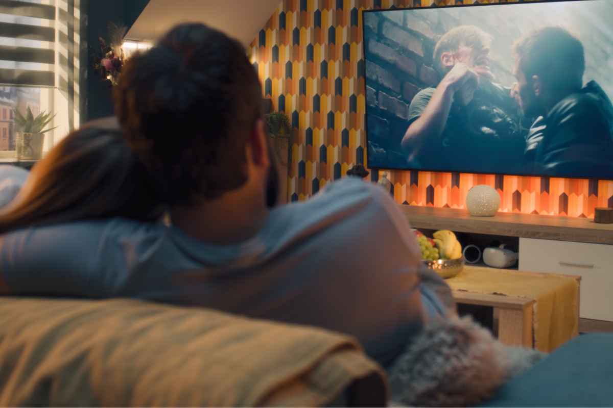 Coppia seduta sul divano mentre guarda un film