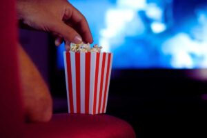 Una mano immersa in una busta di popcorn