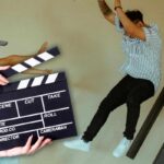 Ciak e persone che si lanciano in secondo piano