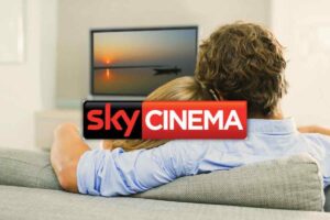 Coppia seduta sul divano e logo Sky cinema