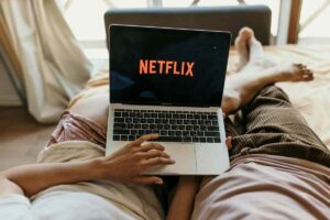Persone con computer sulle gambe e Netflix