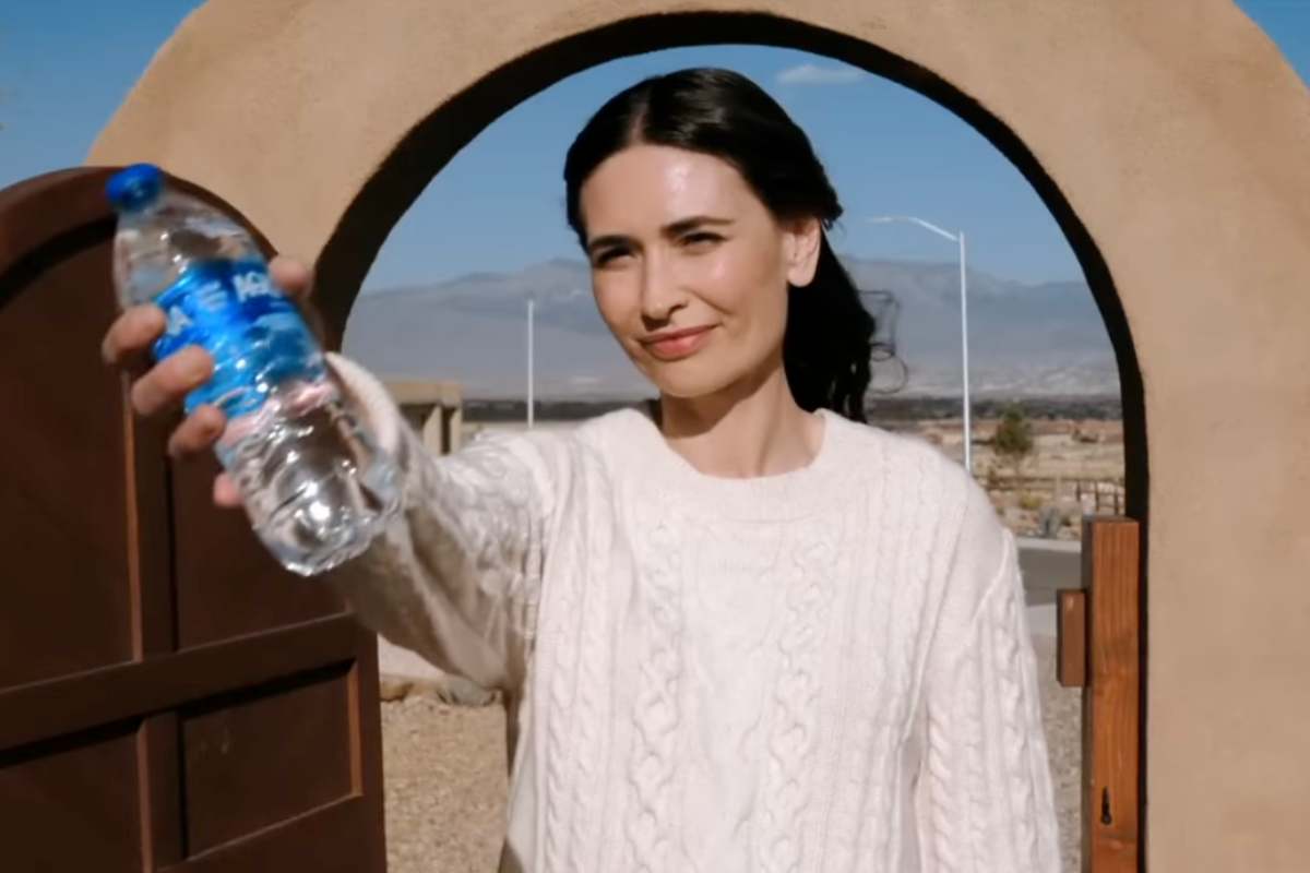 Una donna porge una bottiglia d'acqua