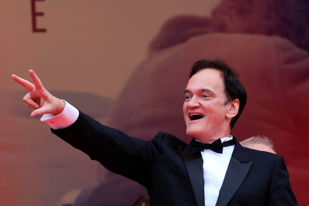 Quentin Tarantino esulta con il braccio leggermente sollevato e due dita a vittoria