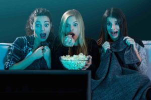 Tre donne sedute sul divano con pop corn in mano