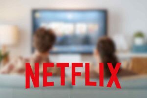 Sfondo appannato con due persone che guardano la tv e la scritta Netflix