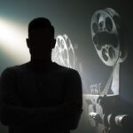 Cinepresa antica e uomo in primo piano