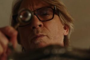 Daniel Craig in una scena del film con la lente di ingrandimento