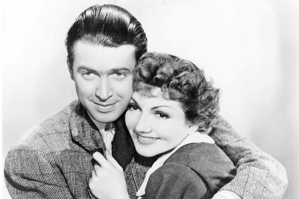 James Stewart in una foto in bianco nero mentre abbraccia l'attrice Claudette Colbert
