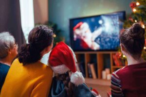 Una famiglia guarda la televisione con un film di Natale
