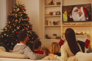 Famiglia seduta sul divano che guarda un film di Natale