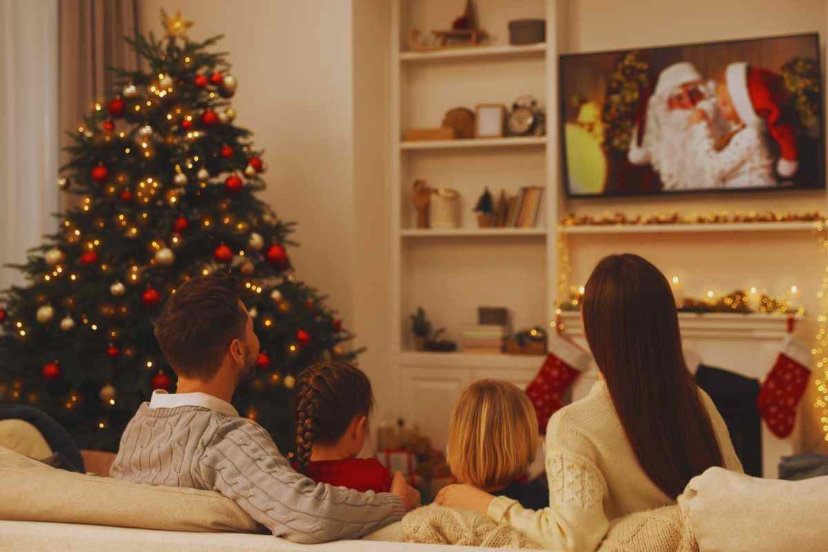 Famiglia seduta sul divano che guarda un film di Natale