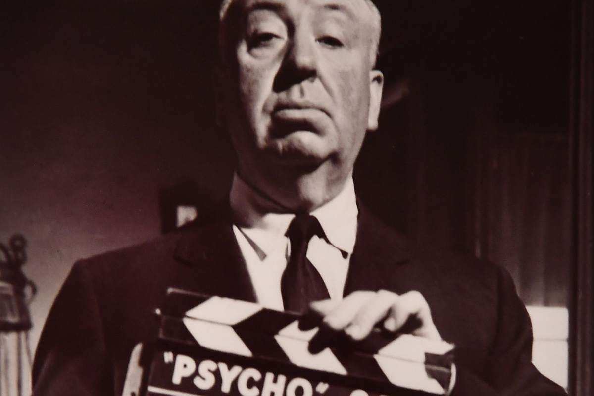 Alfred Hitchcock con un ciak in mano