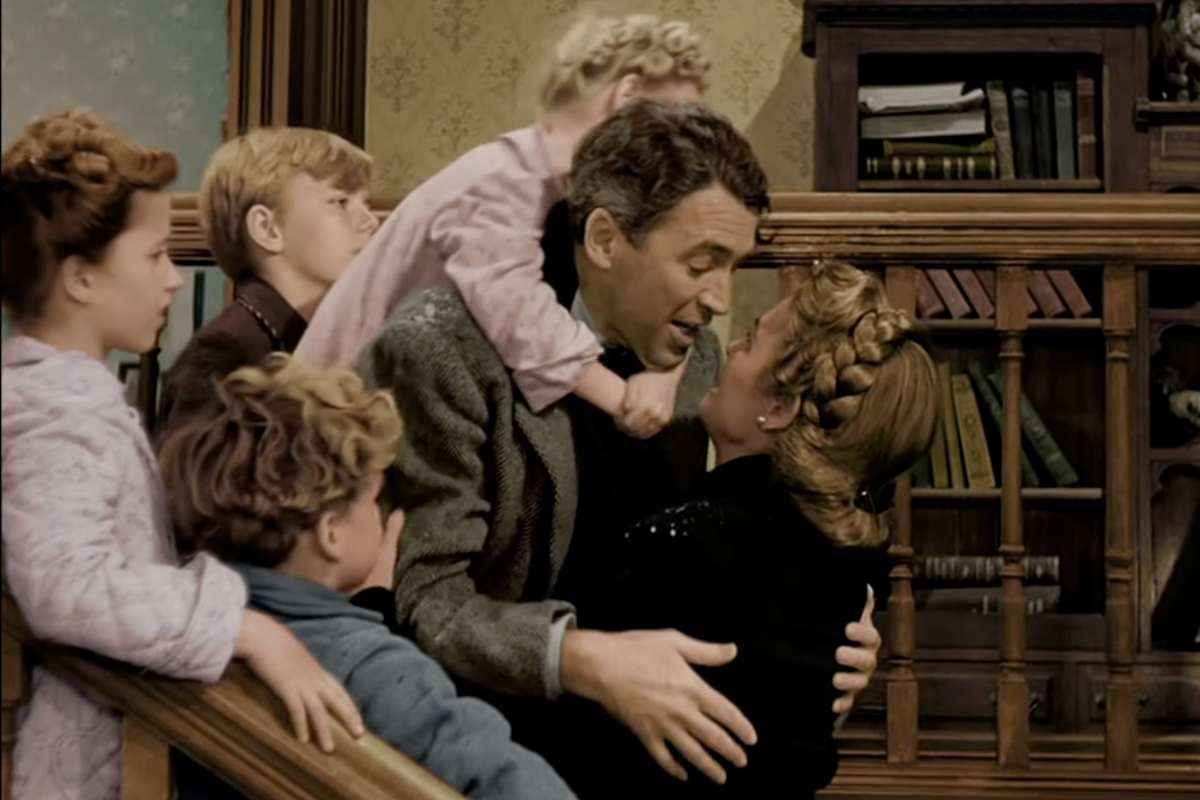 James Stewart in una scena de La vita è meravigliosa con tutti i bambini in braccio