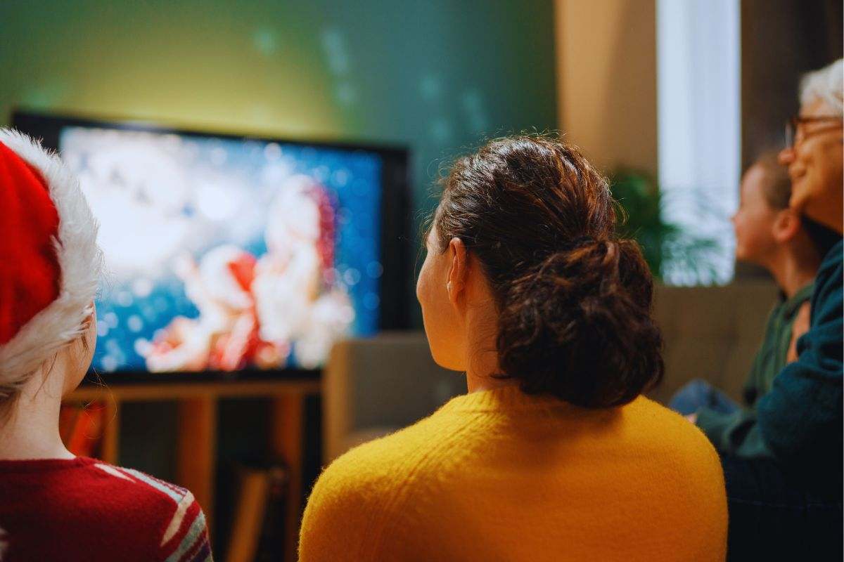Mamma, nonna e nipotine che guardano la tv a Natale