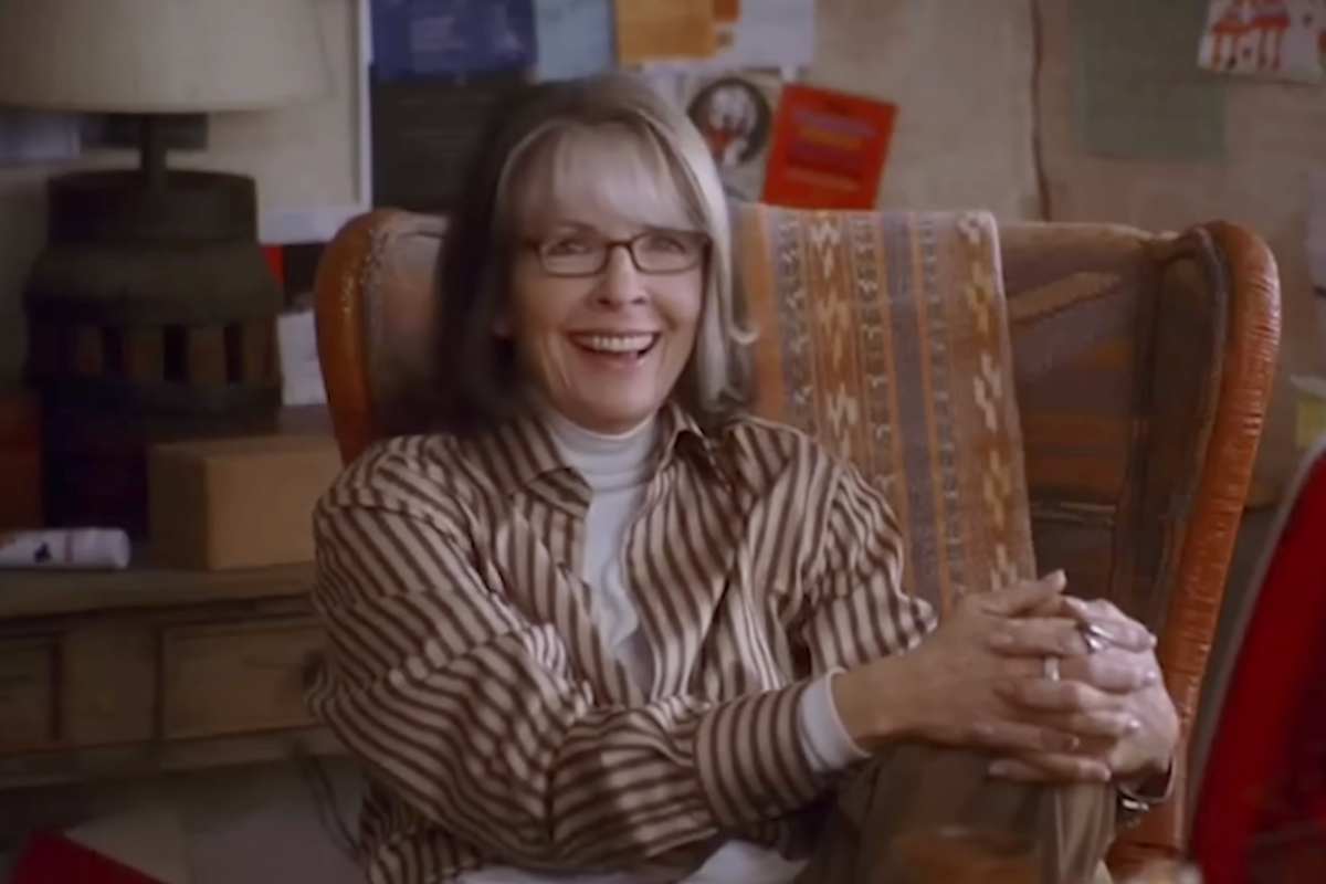 Diane Keaton seduta sorride in una scena del film 'La neve nel cuore'