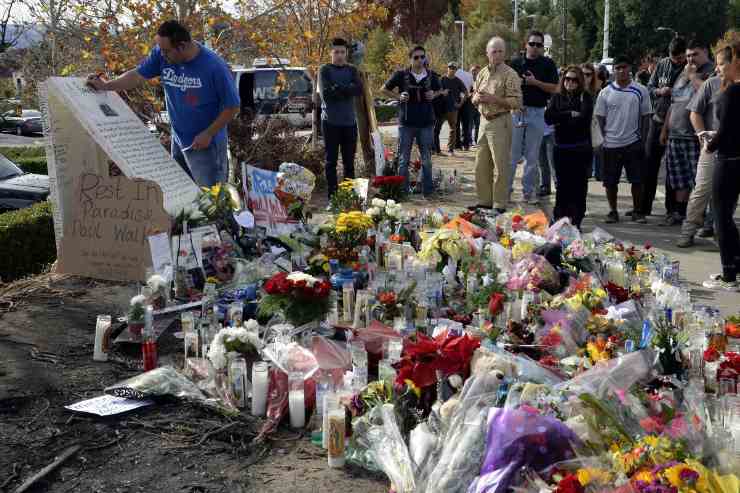 Alcune persone che depositano dei fiori sul luogo dell'incidente di Paul Walker