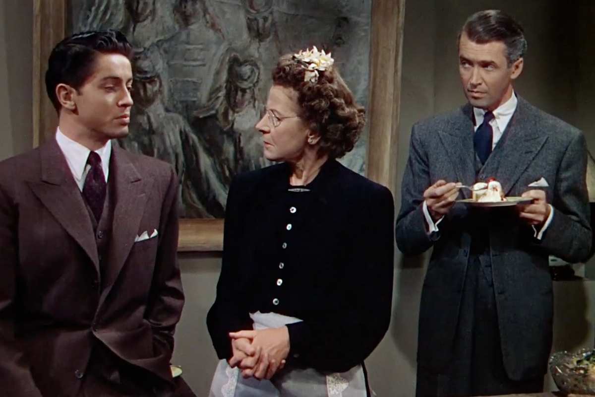 Una scena di Nodo alla gola con tre dei suoi protagonisti: James Stewart sulla destra con un dolce in mano, Edith Ewanson la cameriera al centro mentre parla con uno degli assassini, Farley Granger