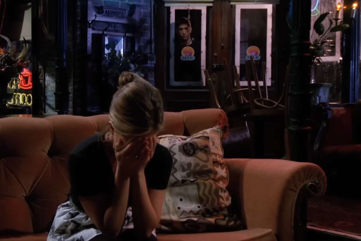 Una puntata di Friends con Rachel seduta sul divano che piange mentre Ross la osserva da dietro la porta a vetri dell'ingresso del locale il Central Perk