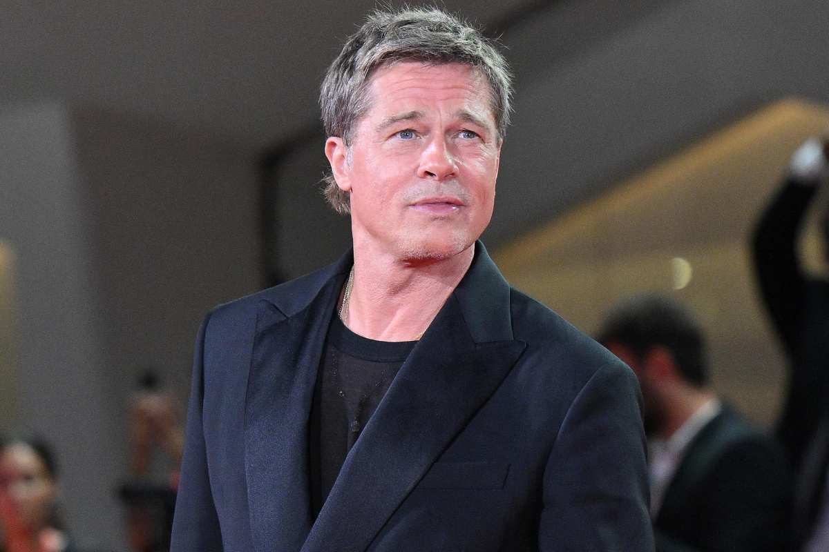 Brad Pitt in abito nero elegante in posa per i fotografi