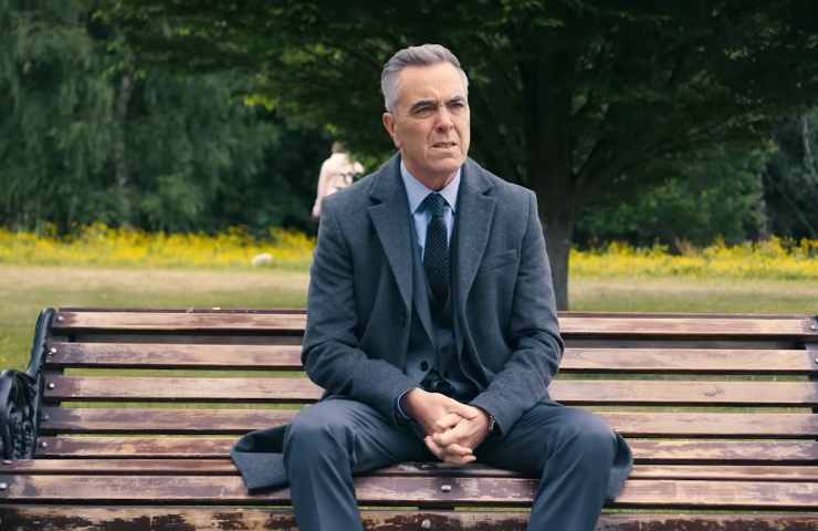 Un uomo seduto su una panchina in un parco