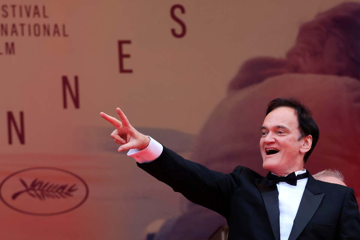 Quentin Tarantino a Cannes saluta con un braccio alzato facendo il segno della vittoria