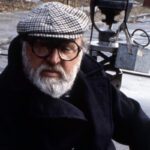 Sergio Leone posa in foto con un berretto in testa ed un giaccone nero