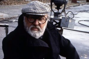 Sergio Leone posa in foto con un berretto in testa ed un giaccone nero