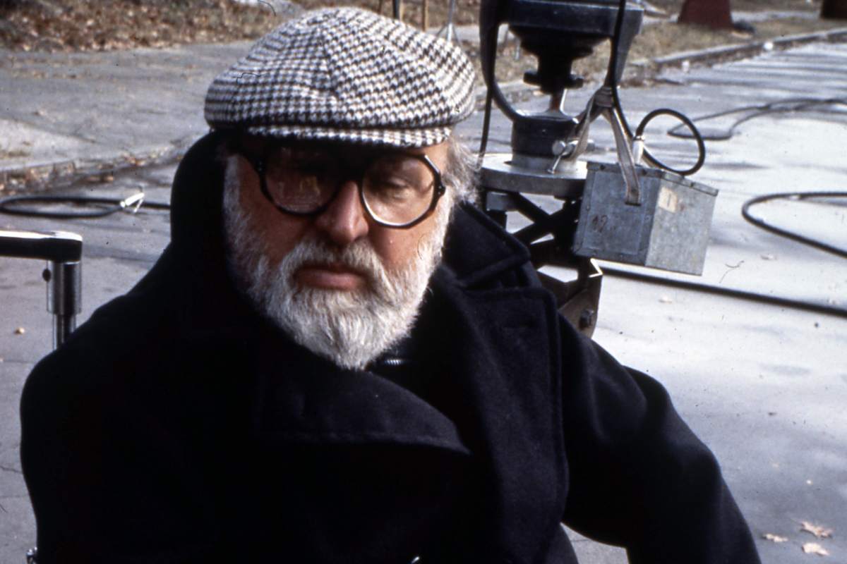 Sergio Leone posa in foto con un berretto in testa ed un giaccone nero