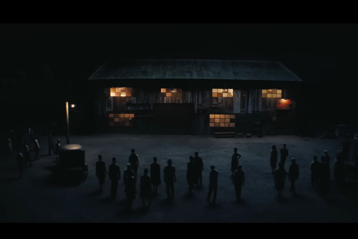 Una casa al buio con delle persone che si avvicinano 