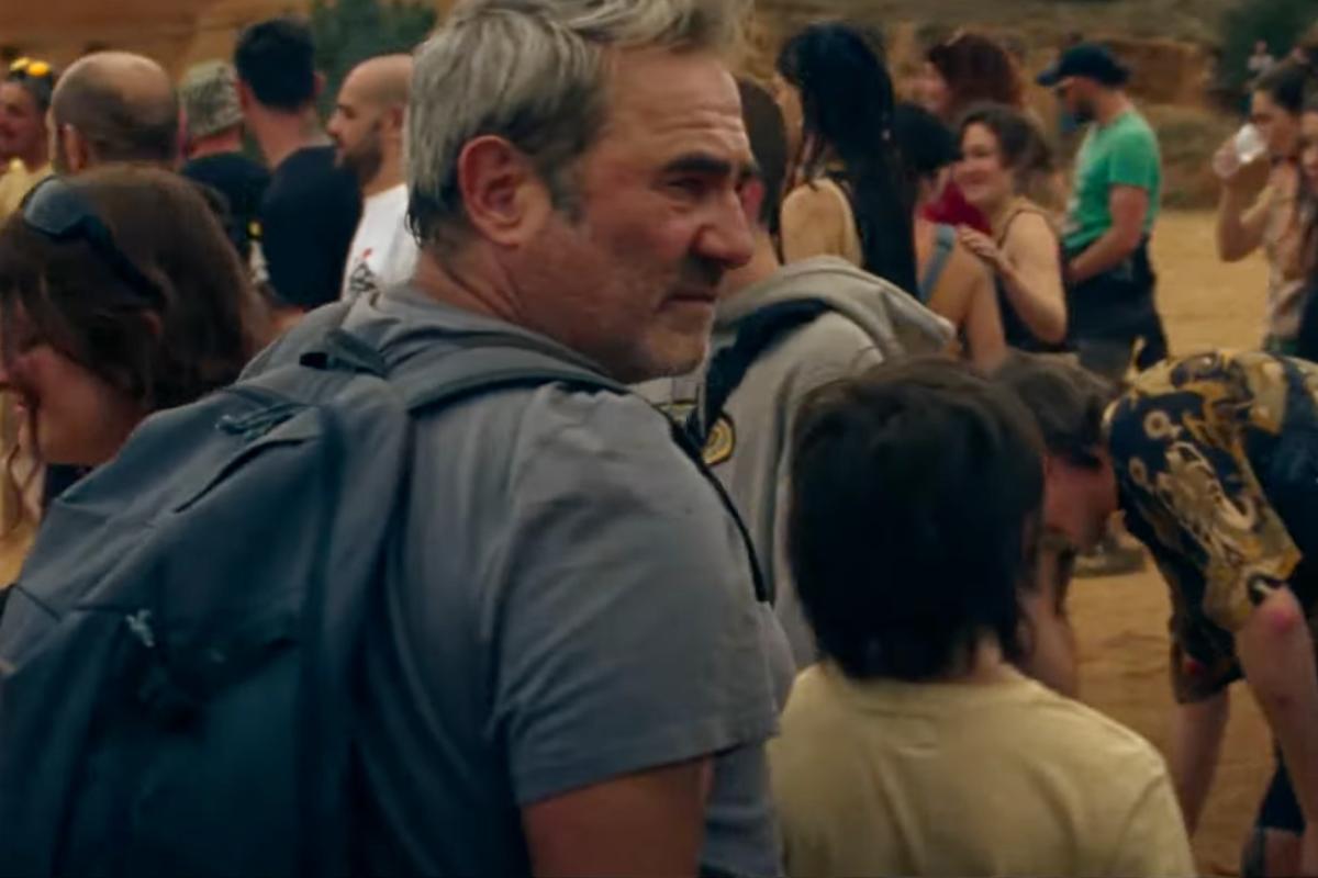 Un uomo con un ragazzino accanto camminano in mezzo alla folla