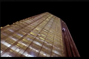 Un edificio di vetri ripreso dal basso con l'ascensore visibile