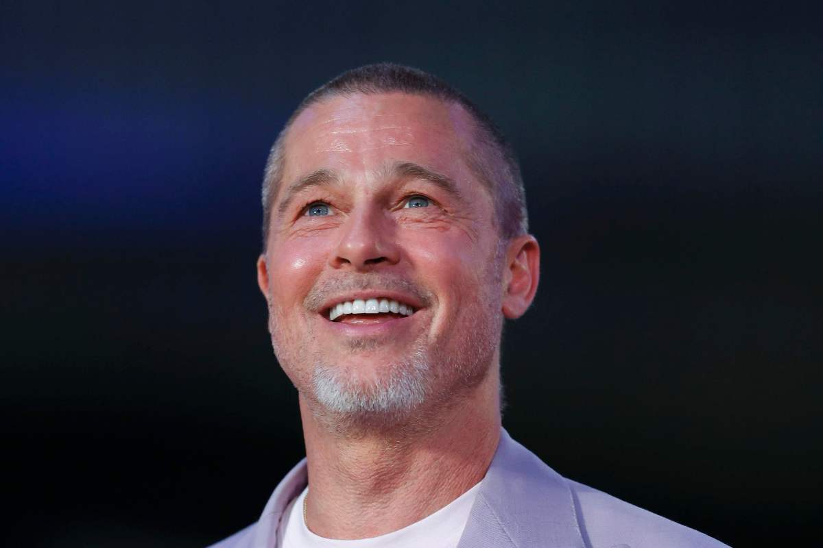 Brad Pitt sorridente guarda verso l'alto