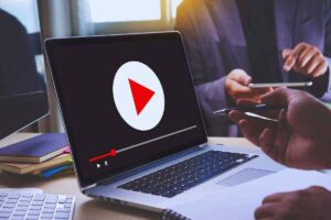 Computer portatile aperto con la freccia di accensione di un video presumibilmente su YouTube