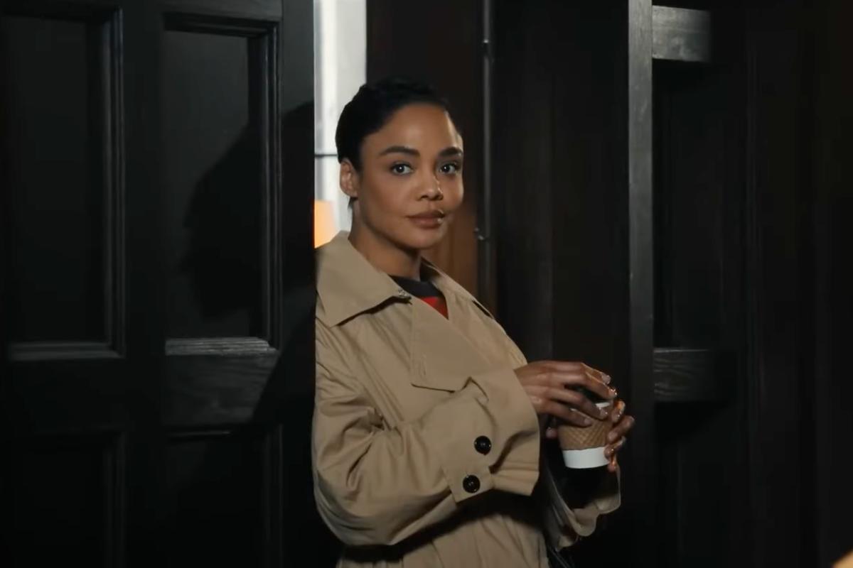 Tessa Thompson appoggiata ad una porta con lo sguardo rivolto alla sua destra