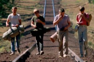 Quattro ragazzi camminano sui binari del treno