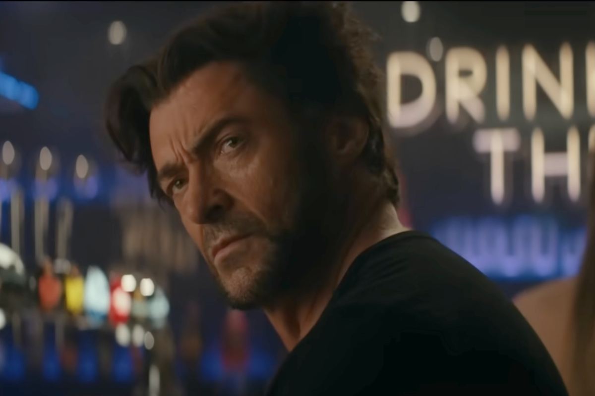 Hugh Jackman seduto su una sedia volge lo sguardo alle sue spalle