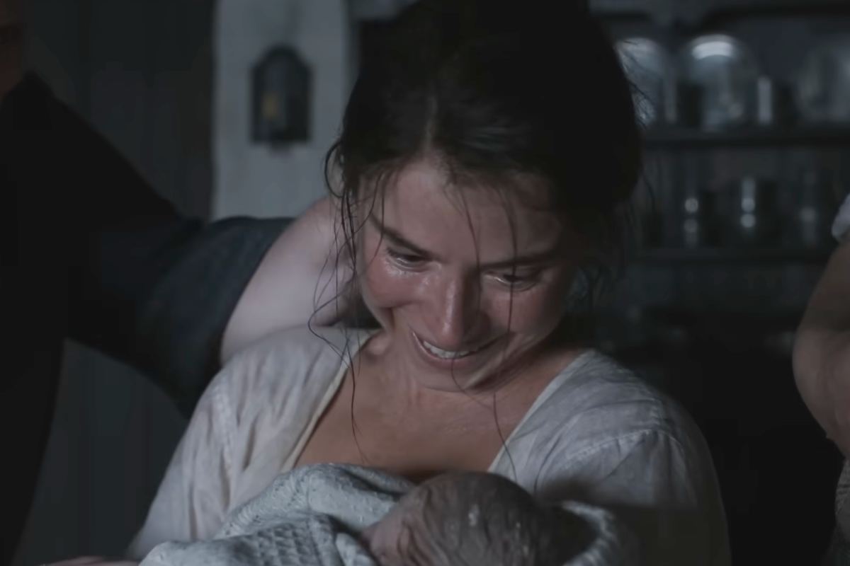 Jessie Buckley nei panni di Agnes in una scena del film 'Hamnet' con in braccio un neonato