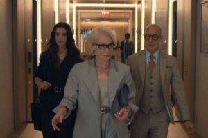 Meryl Streep, Stanley Tucci e Anne Hathaway insieme camminano lungo un corridoio in una scena del film Il diavolo veste Prada 2