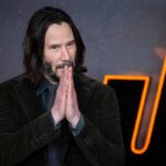 Keanu Reeves con le mani giunte in preghiera ringrazia il pubblico alla presentazione di John Wick