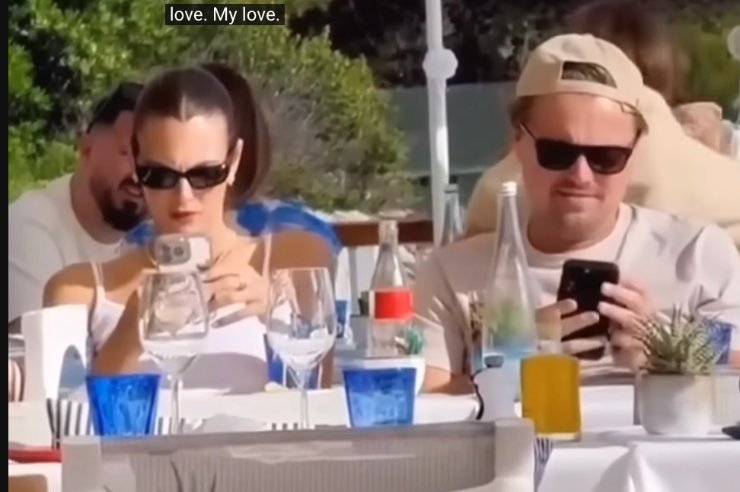 Vittoria Ceretti e Leonardo DiCaprio controllano il cellulare seduti l'uno accanto all'altra