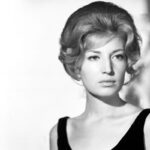 Immagine mezzo busto di Monica Vitti con un abito nero e i capelli raccolti